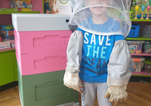 Chłopiec w niebieskiej koszulce w stroju pszczelarza